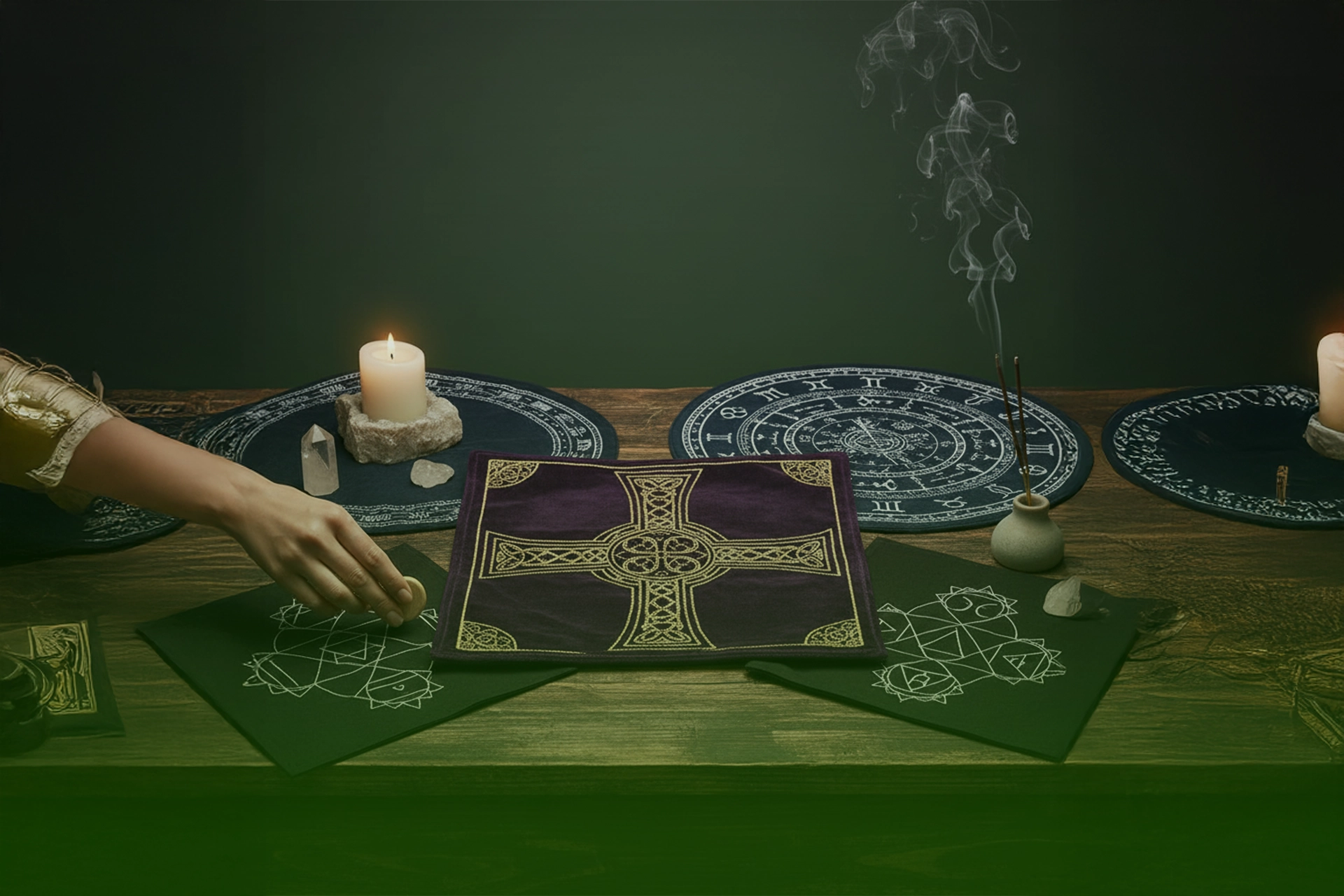 Mesa ritual con tapetes de lectura (zodiaco y geometría sagrada) y paño morado con cruz celta, junto a vela, cuarzos e incienso.