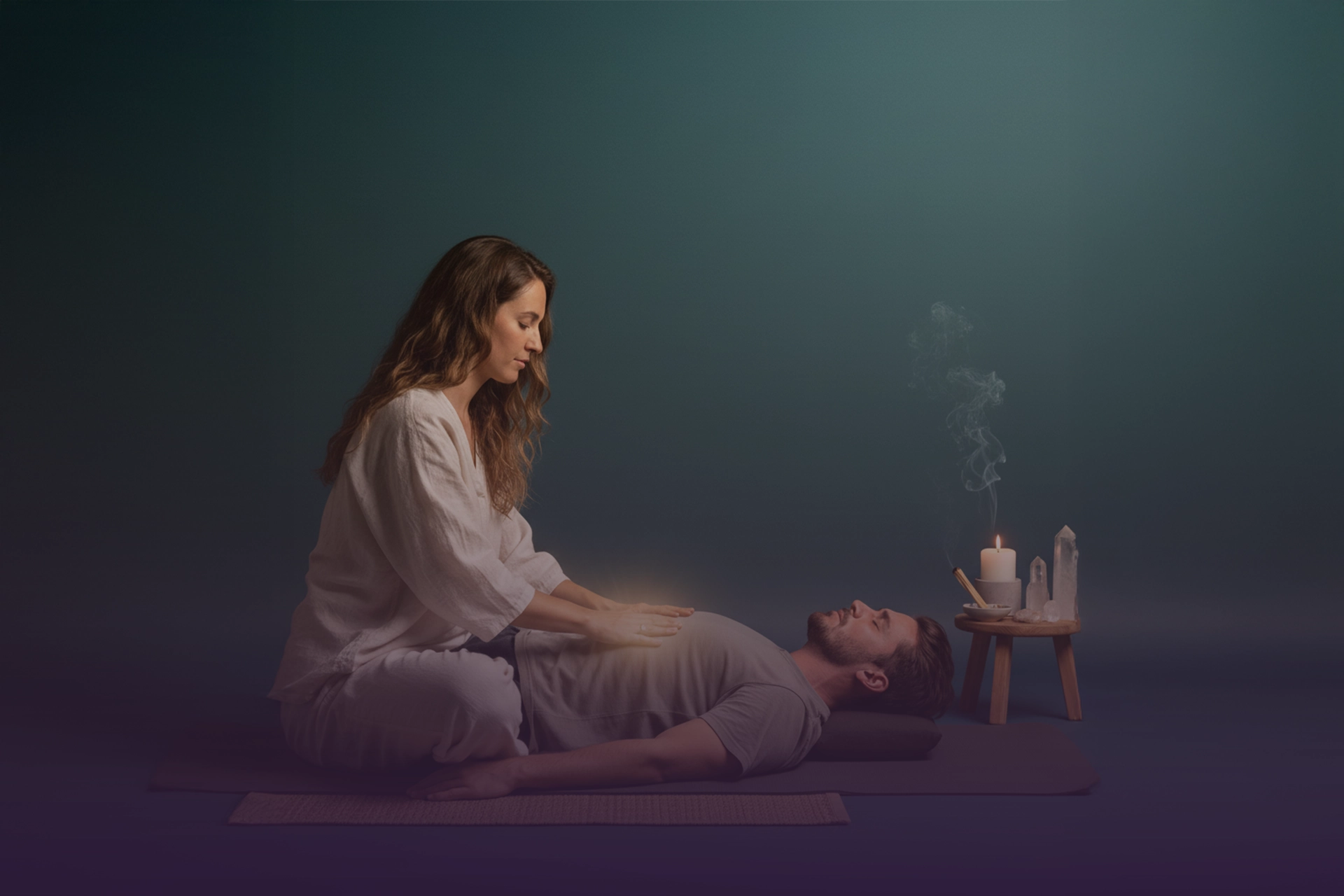 Facilitadora guiando respiración consciente con manos sobre el pecho del practicante; vela, incienso y cristales al fondo.